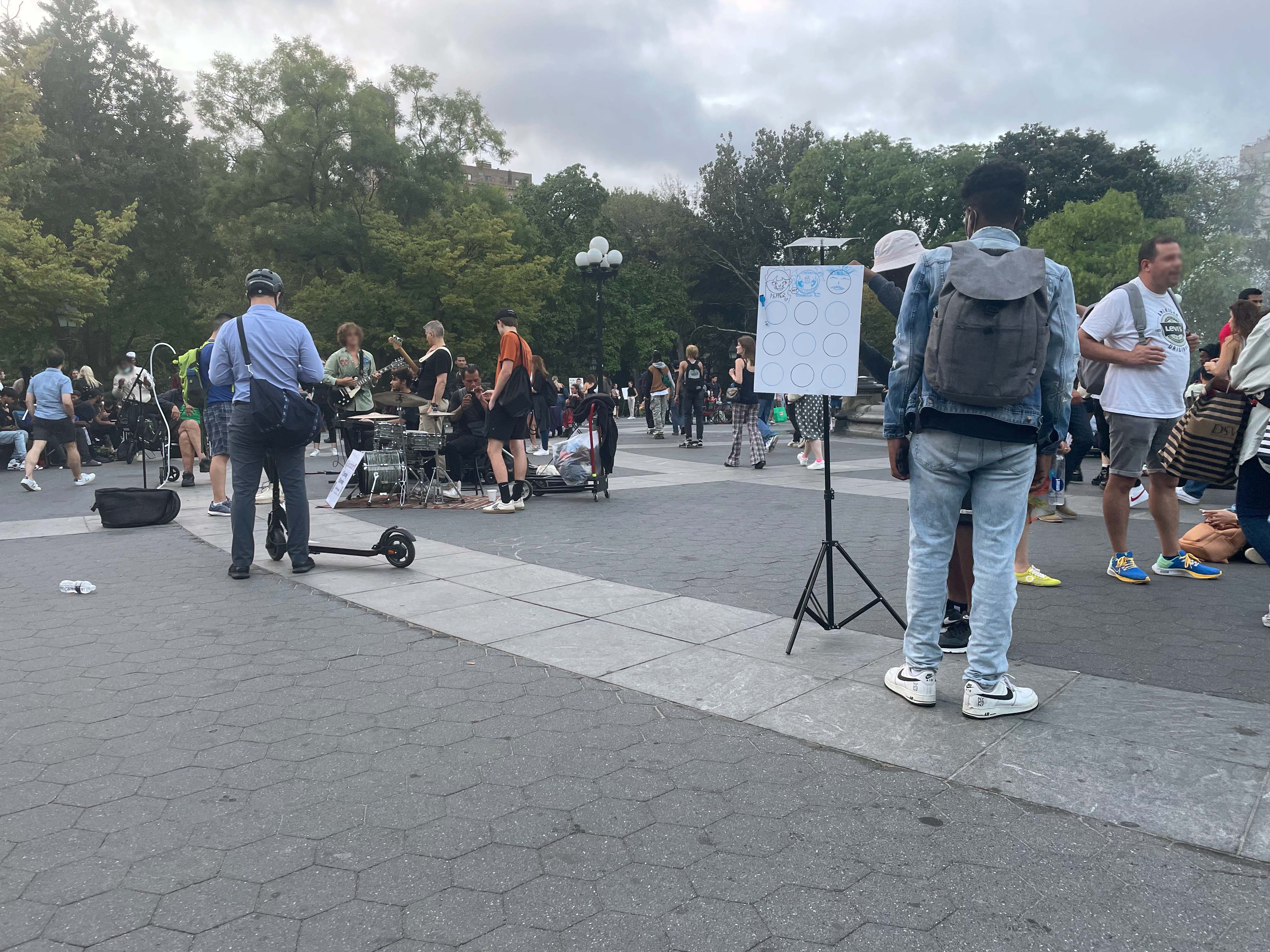 Two men drawing on prototype 2 in front of a live band