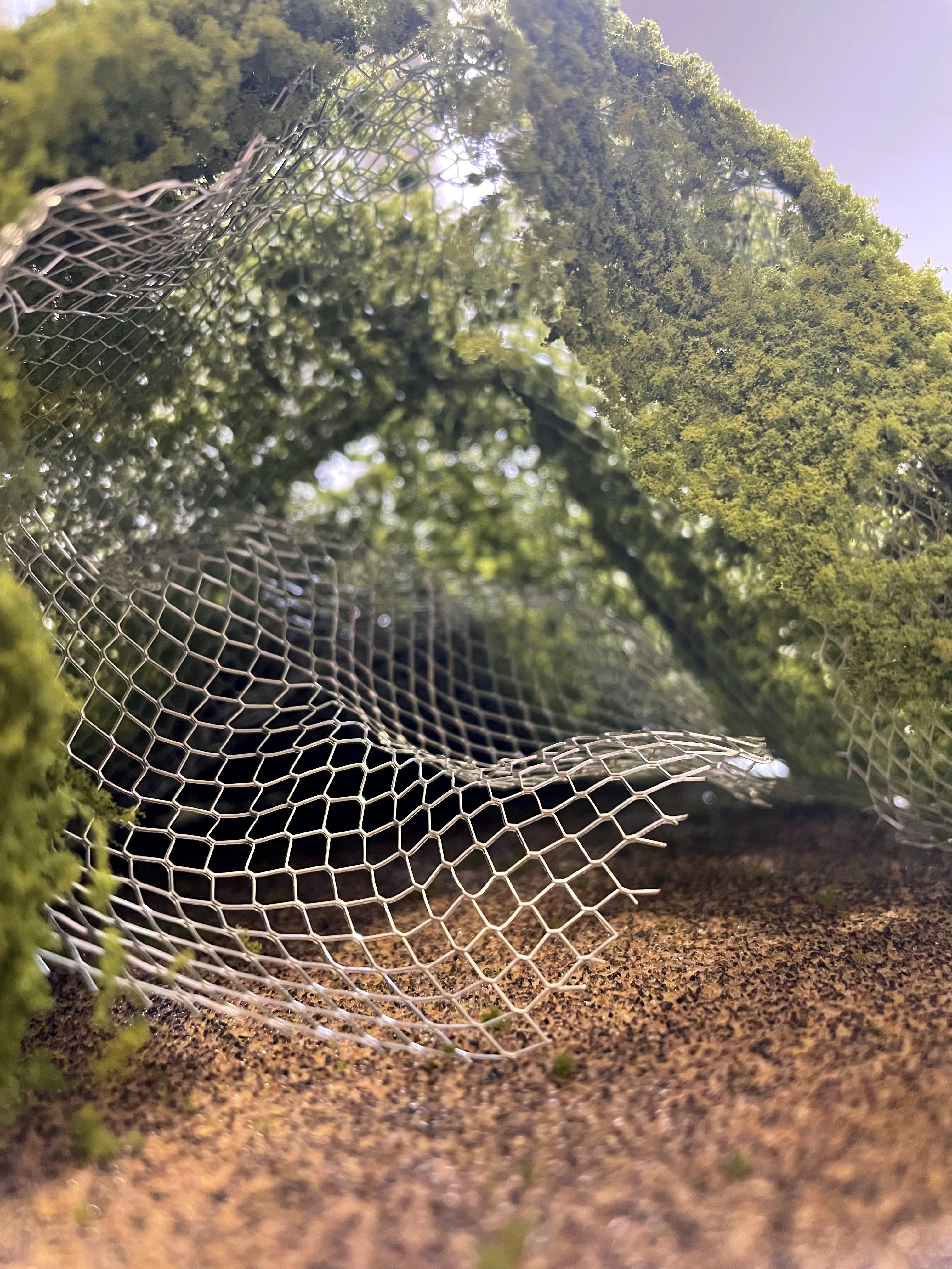 Close up of the interior of the wire model prototype with a green, foliage-like covering.